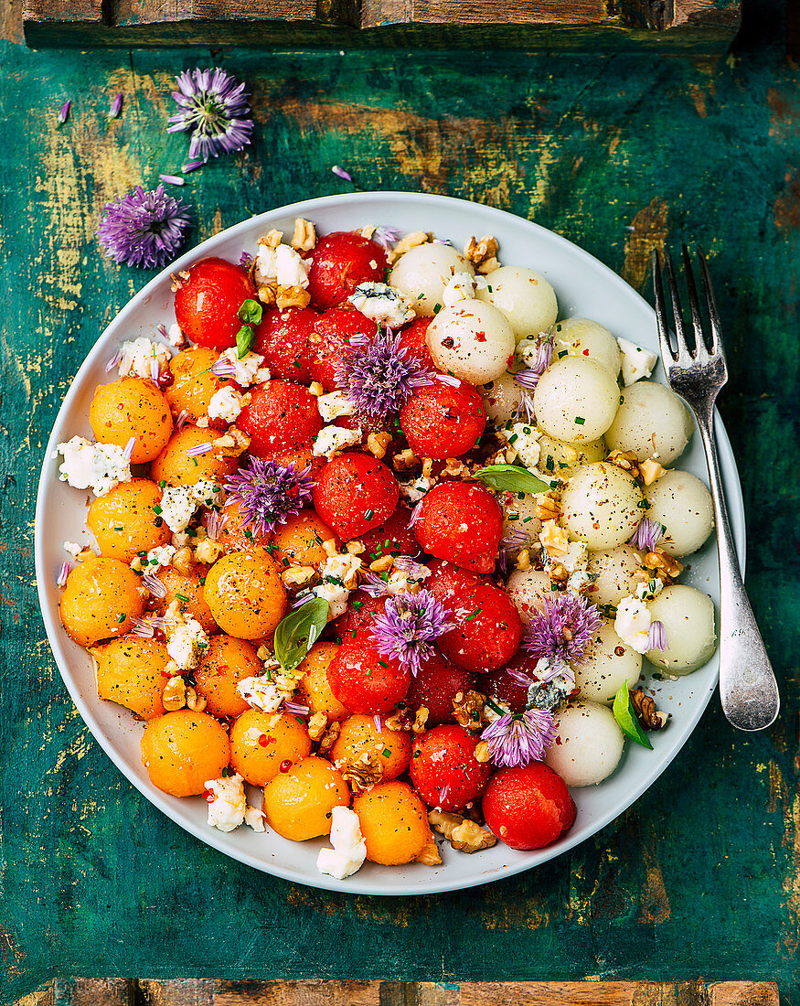 Summer melon salad with chive blossoms and nuts