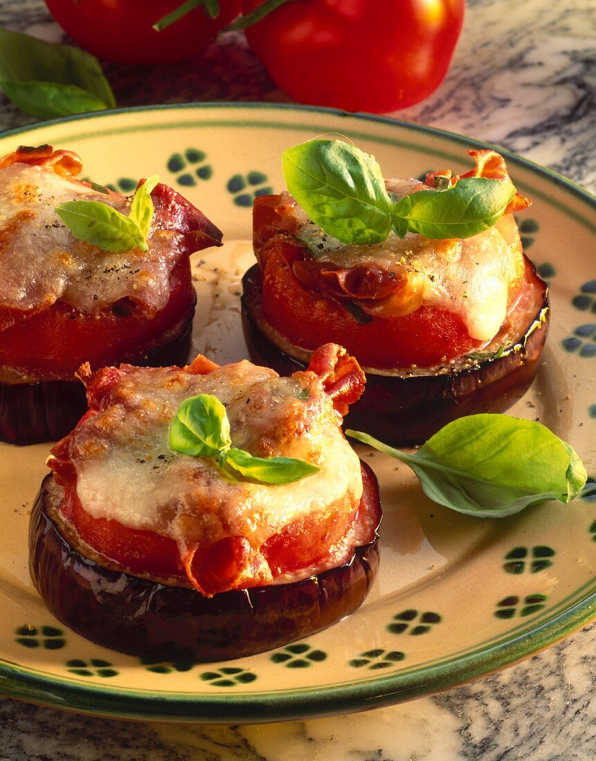 Baked aubergine slices with tomato, cheese, basil