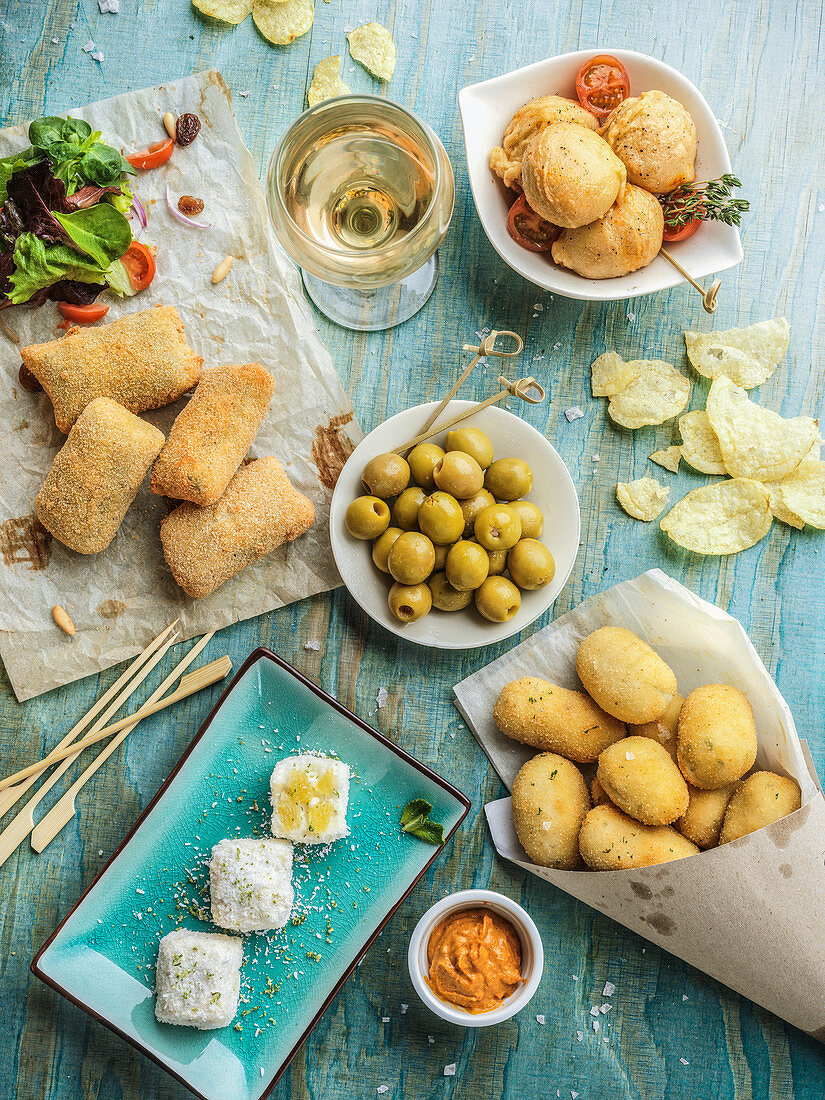 Verschiedene Kroketten serviert mit Oliven und Wein
