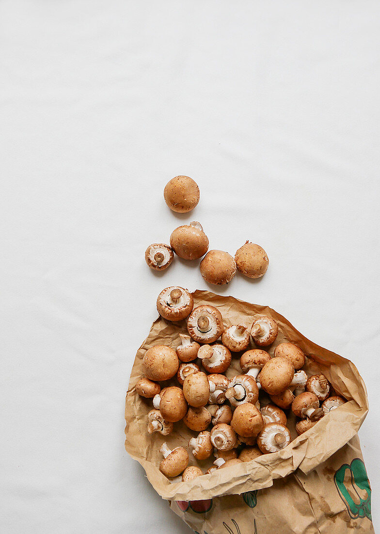 Fresh button mushrooms in a paper bag