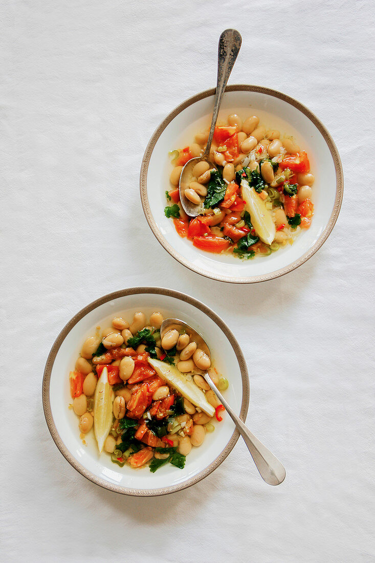 Bean soup with tomatoes and lemon wedges