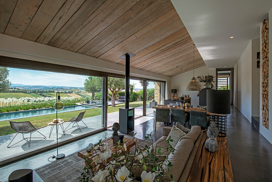 Seating area in open-plan interior with sliding glass door and terrace