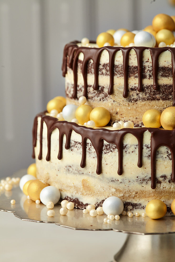 Le gâteau d'anniversaire au chocolat avec des boules dorées et la