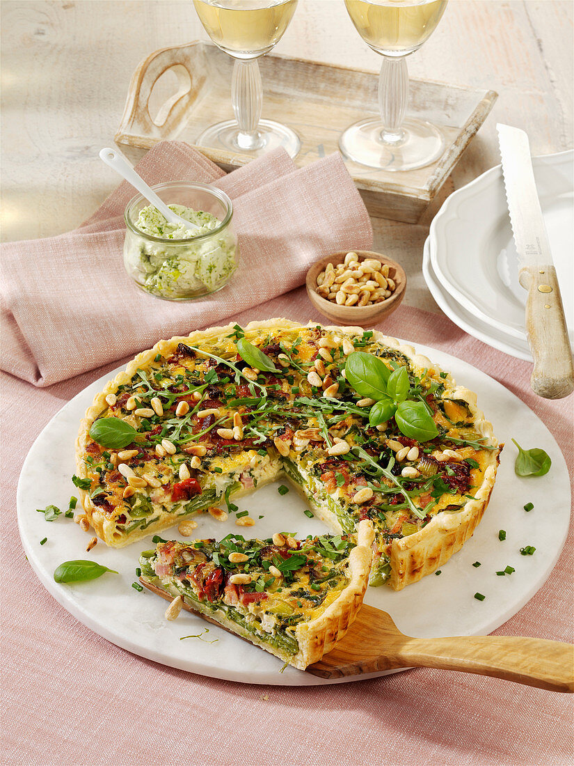 Herb quiche with bacon, sun-dried tomatoes and pine nuts