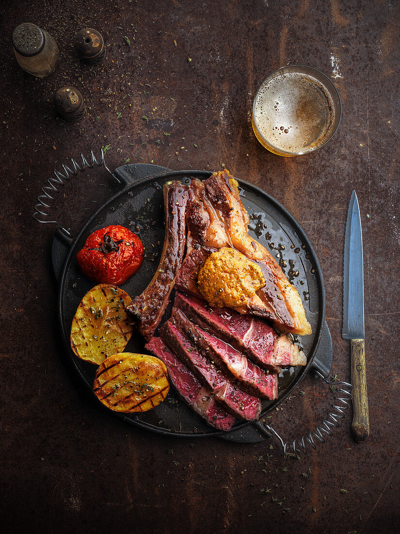 Gegrilltes Rindersteak mit Kartoffeln und Tomaten aus dem Ofen