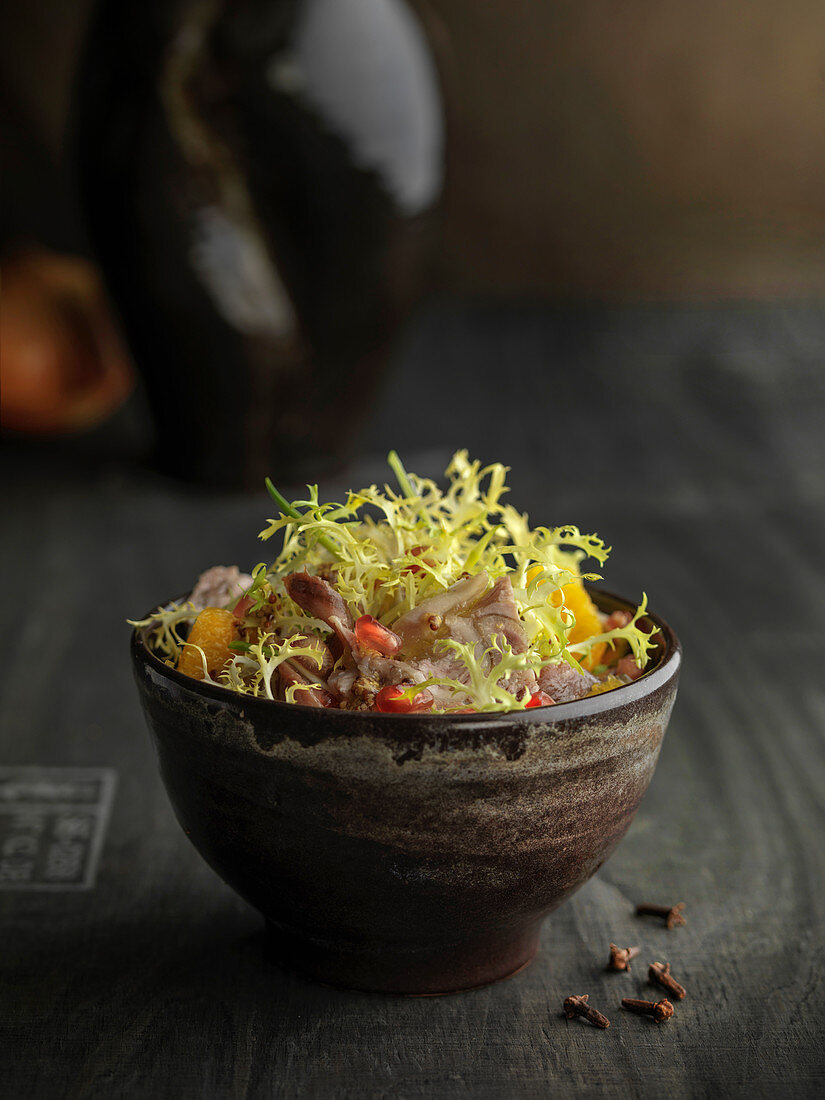 Frisée salad with oranges, pomegranate seeds and meat