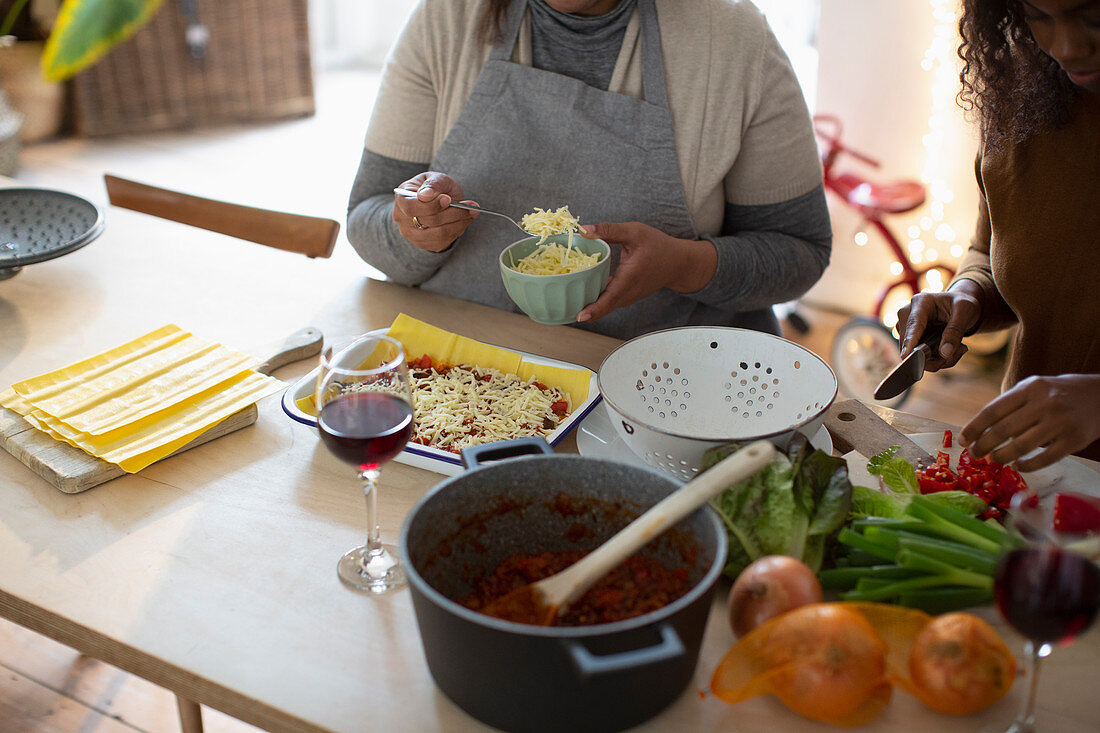 Mother and daughter making homemade lasagne at home