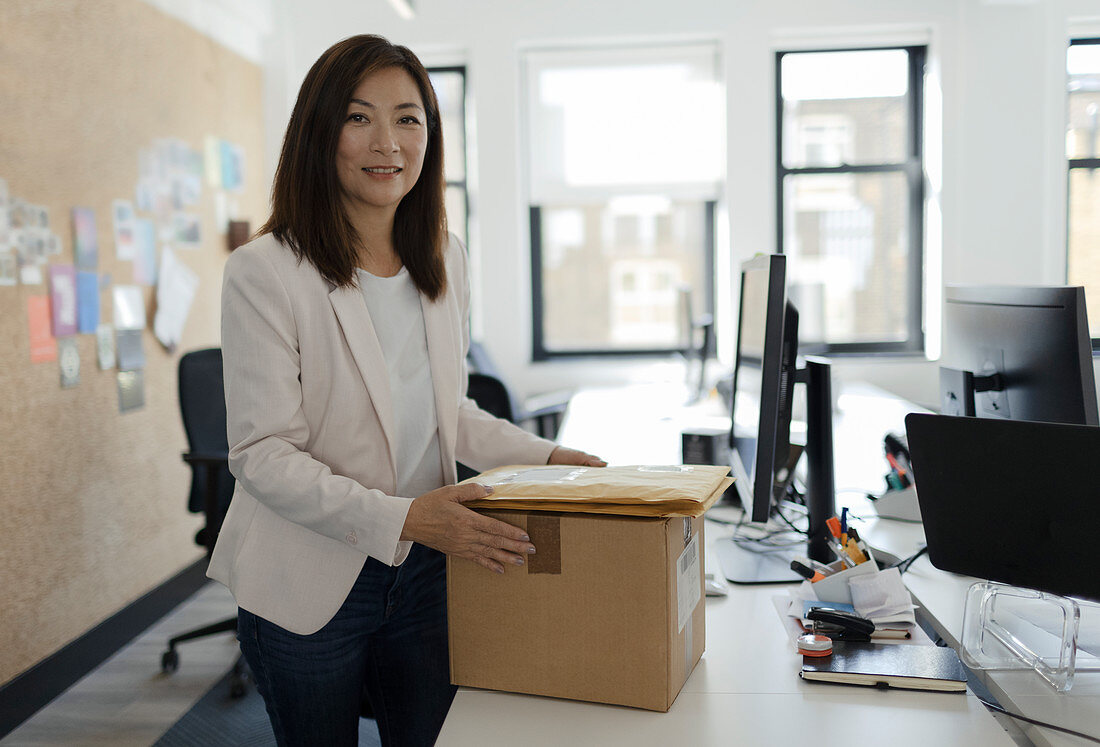 Smiling businesswoman receiving packages in office