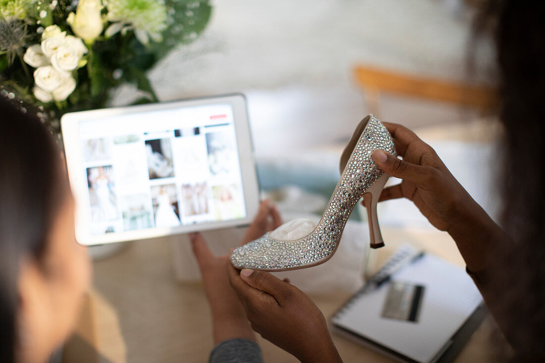 Women with wedding shoe shopping for ideas on digital tablet