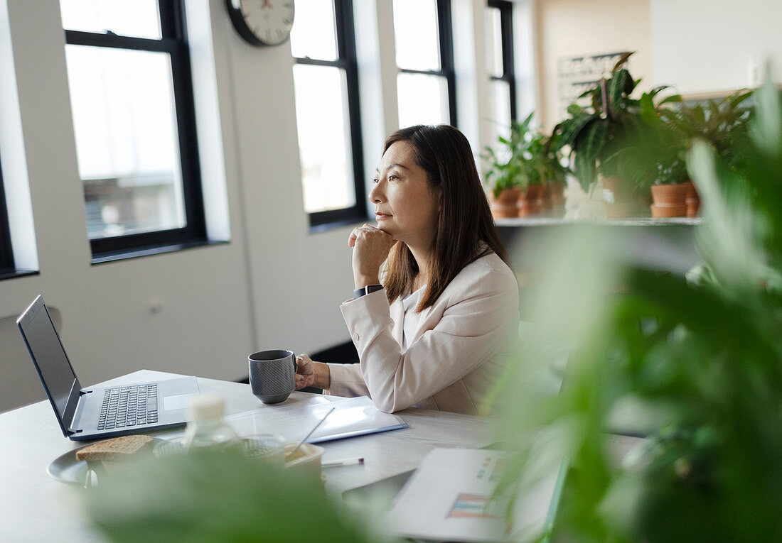 Focused businesswoman working at laptop in office