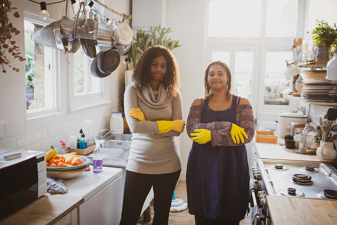Confident mother and daughter cleaning kitchen