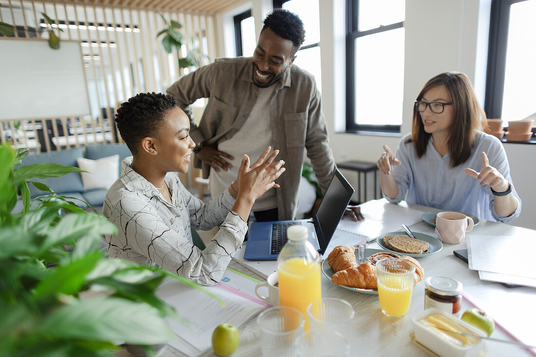 Business people talking over breakfast in office meeting