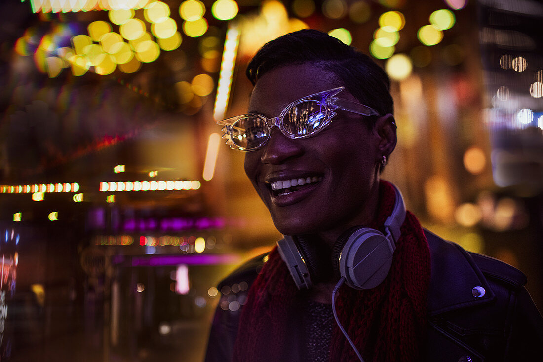 City lights around happy young woman in funky eyeglasses
