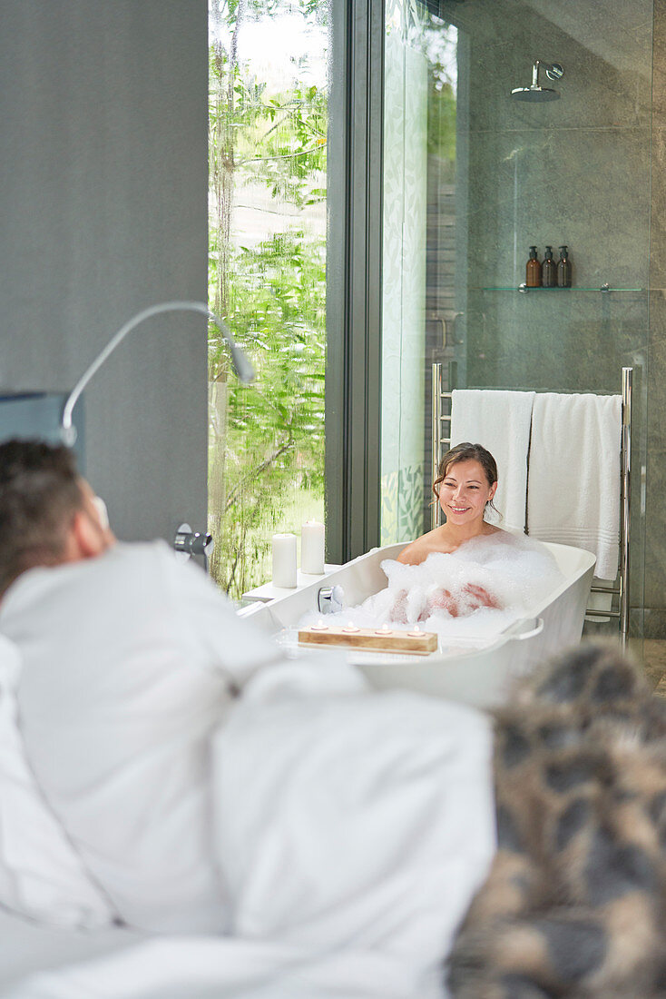 Couple taking bath and laying in bed in luxury hotel room