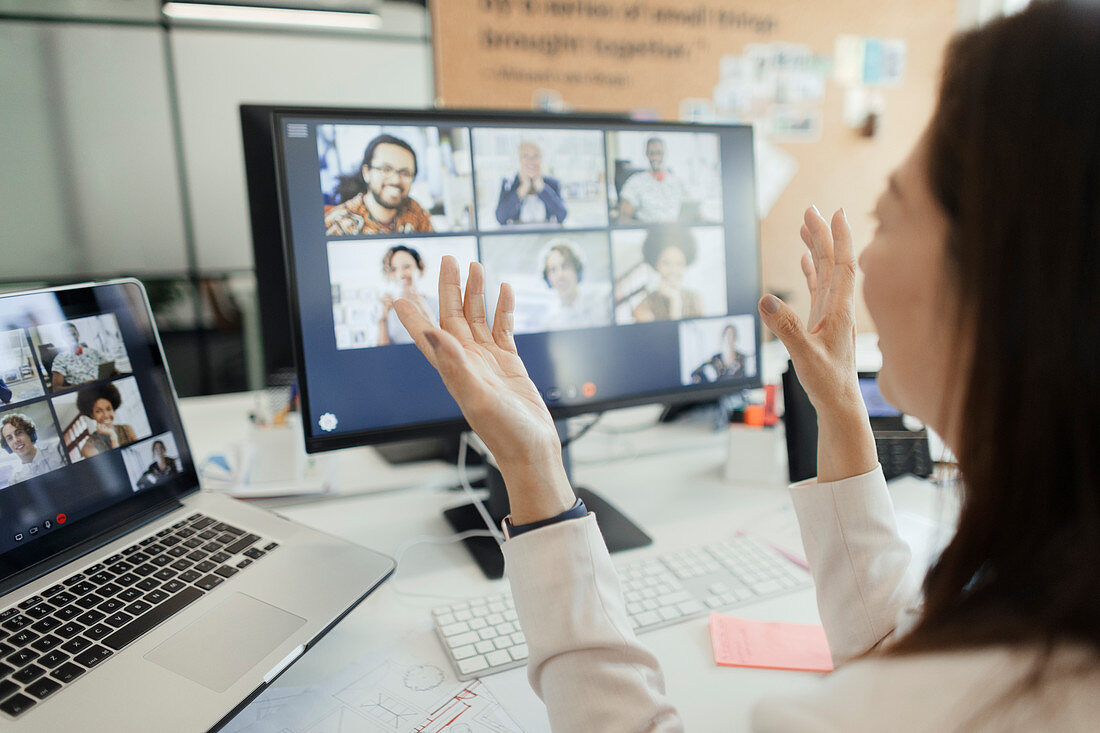 Woman video conferencing with coworkers at computer screen