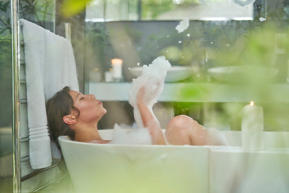 Woman having a bubble bath in luxury soaking tub