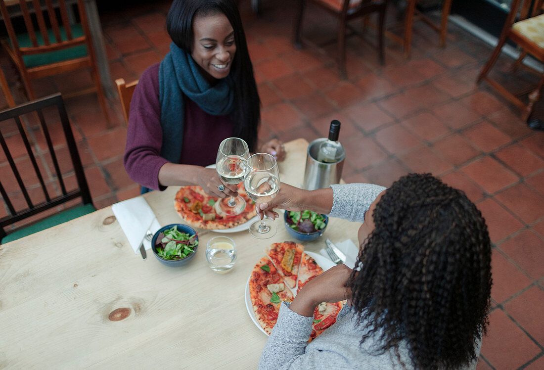 Mother and daughter enjoying wine and pizza at lunch