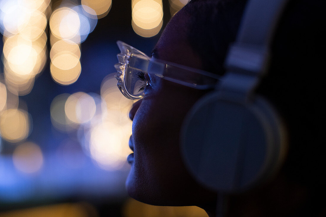 Young woman in glasses and headphones looking at lights