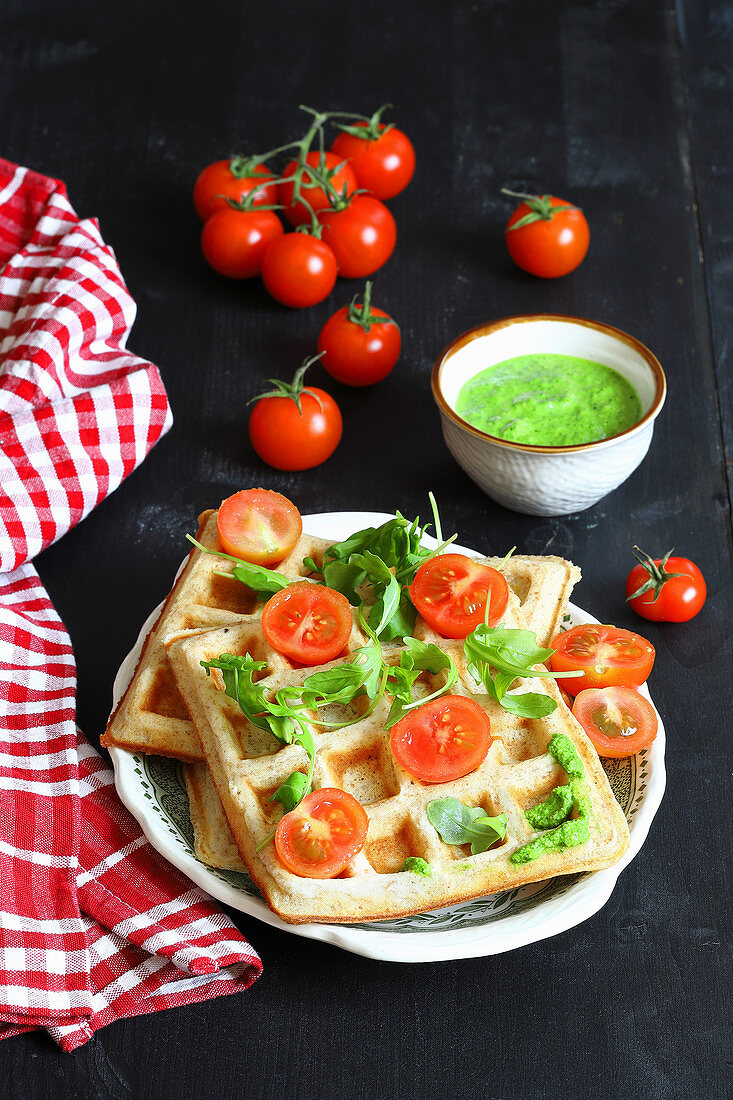 Savory waffles with cheese, herb pesto and tomatoes