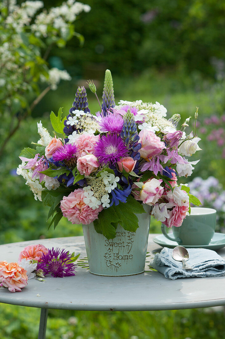 Early summer bouquet with roses, lupins, knapweed, columbine and Viburnum flowers