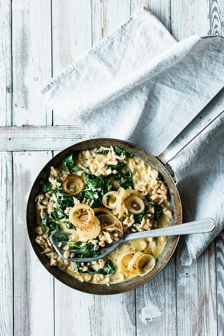 Cheese Knöpfle (soft egg noodles from Switzerland) with spinach and roast onions