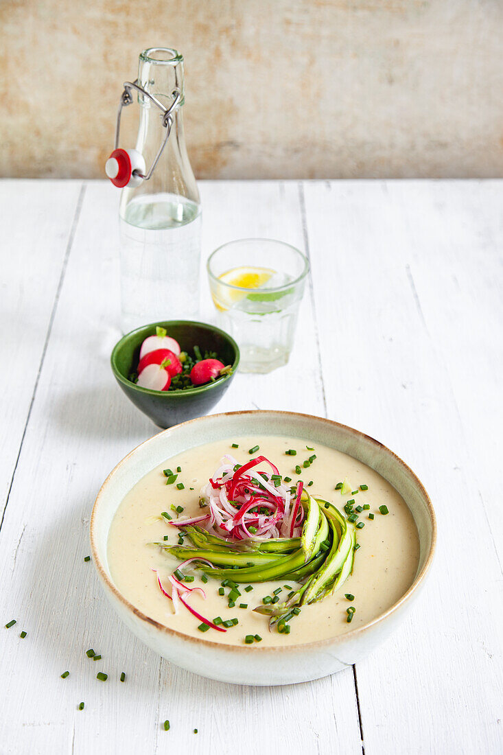 Creamy potato soup with green asparagus and radish