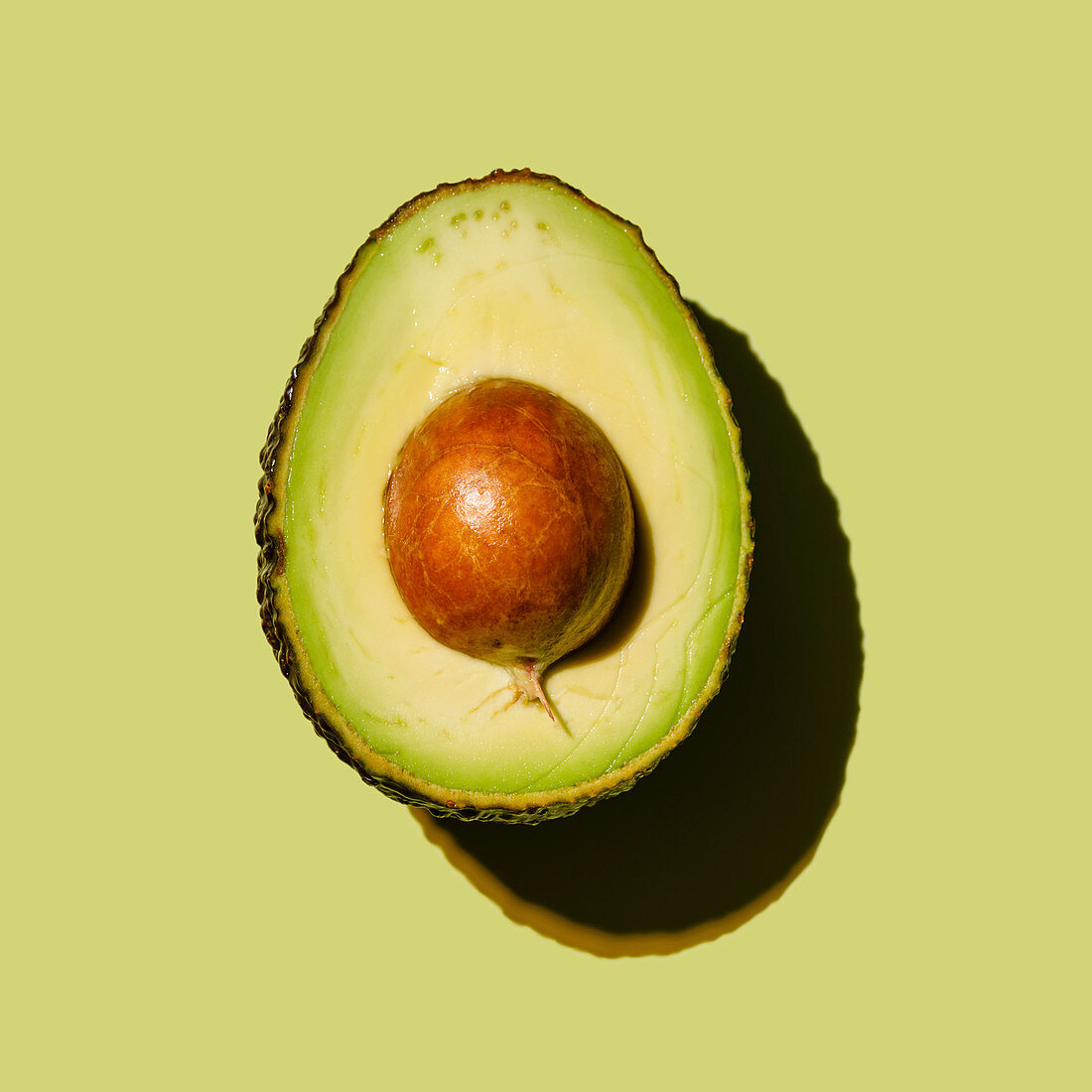 Avocadohälfte auf grünem Hintergrund