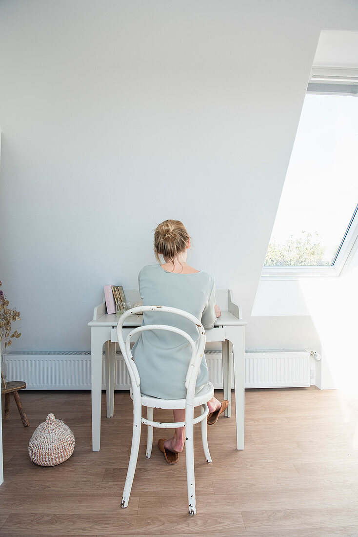 Blonde woman sitting at the desk under the umbrella