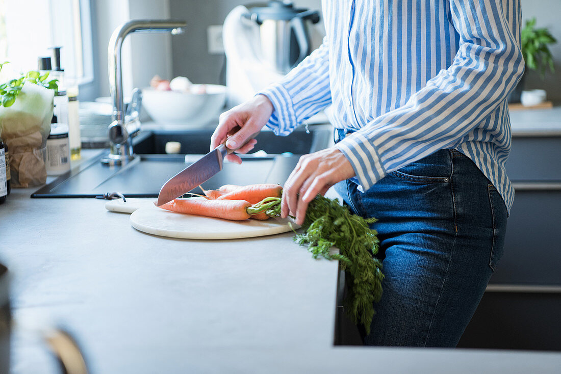 Woman cutting carrots in a kitchen