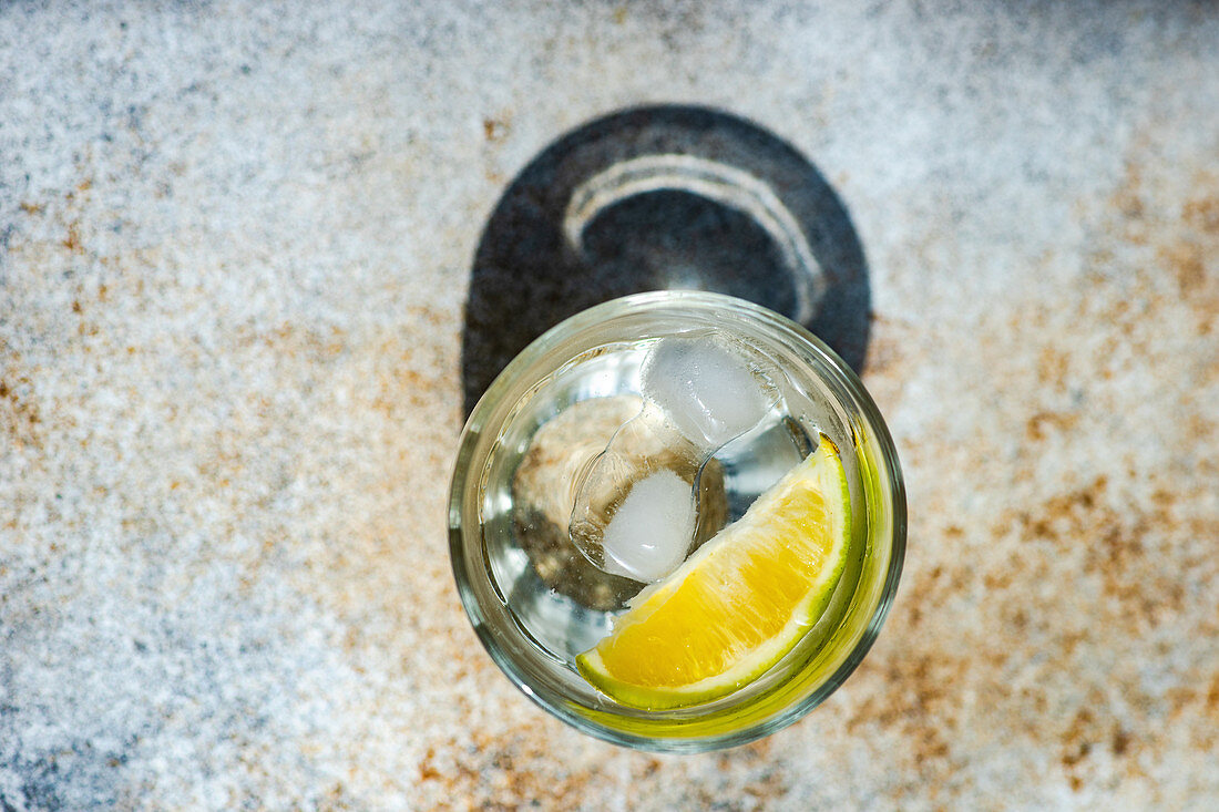 Wasser mit Zitrone und Eiswürfeln auf Betontisch