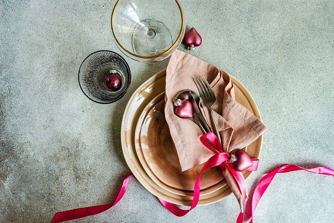 Christmas table setting with dust pink plates and cutlery in served setting for Christmas dinner