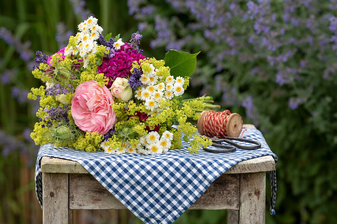 Rustic summer bouquet of roses, lady's mantle, feverfew, lavender and carnations