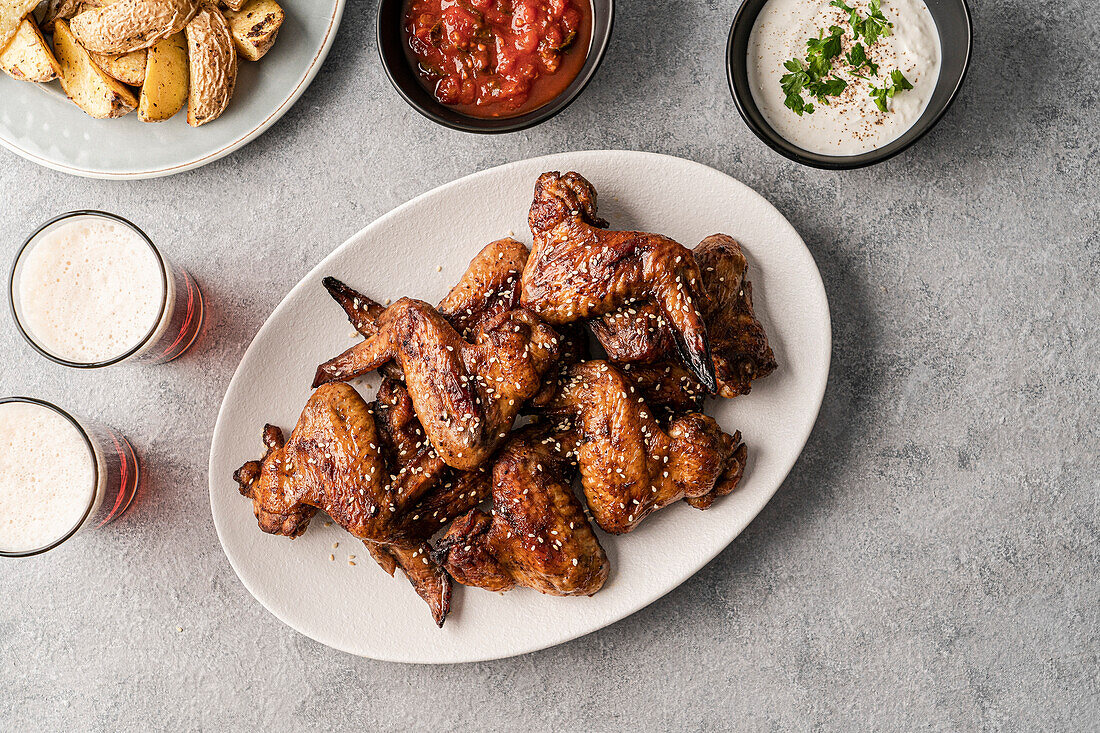 Teriyaki chicken wings with dips, potato wedges and beer