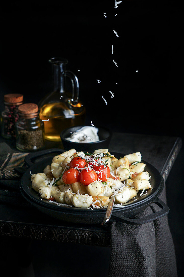 Gnocchi mit Speck, Kräutern, Tomaten und mit Käse bestreuen