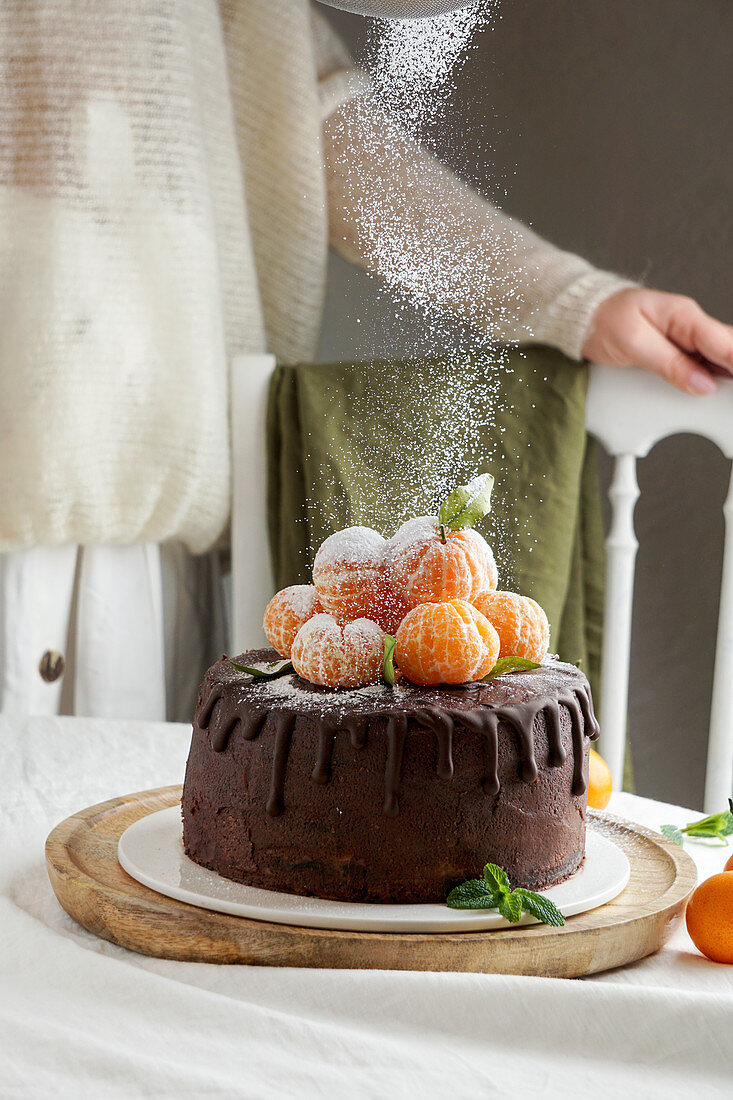 Schokoladen-Dripping-Cake mit Puderzucker bestauben