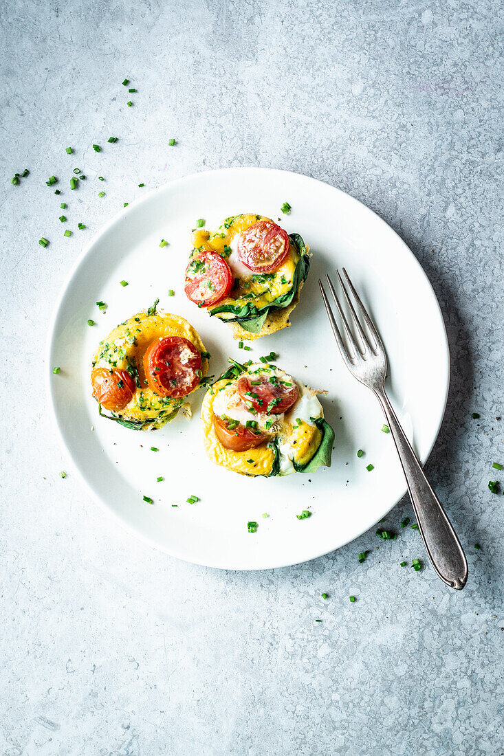 Egg muffins from the oven with spinach and tomatoes