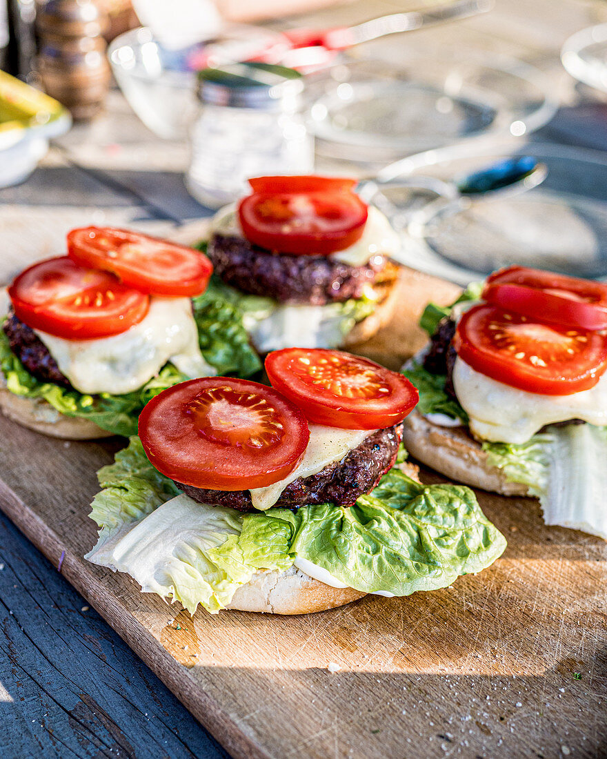 Hamburger mit Salat und Tomate auf Tisch im Freien