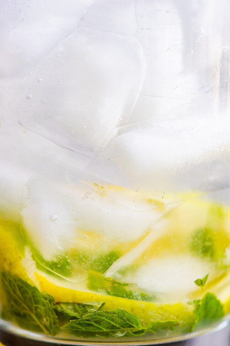 Zitronenwasser mit Eis und Minze im Glas serviert