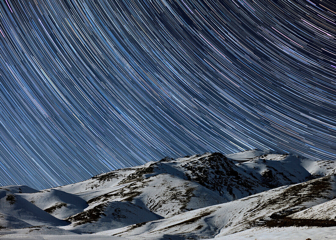 Star trails over snow-covered mountains, Iran