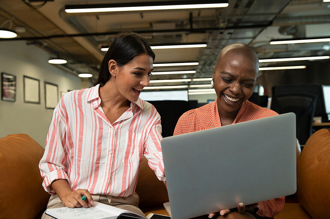 Happy businesswoman working at laptop in office