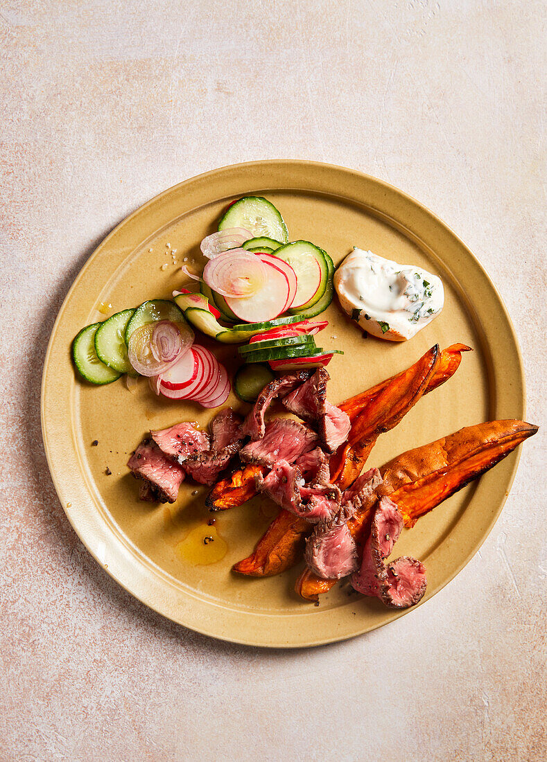 Steak strips with sweet potatoes and cucumber and radish salad
