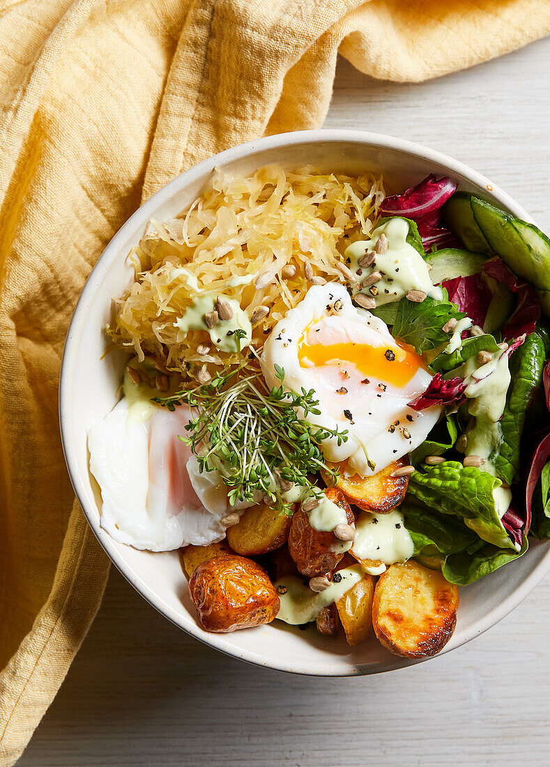 Sauerkraut bowl with poached eggs, avocado and kefir