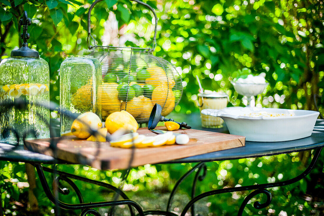 Tischszene mit Zitronen, Zitronenlimo und Zitronendessert