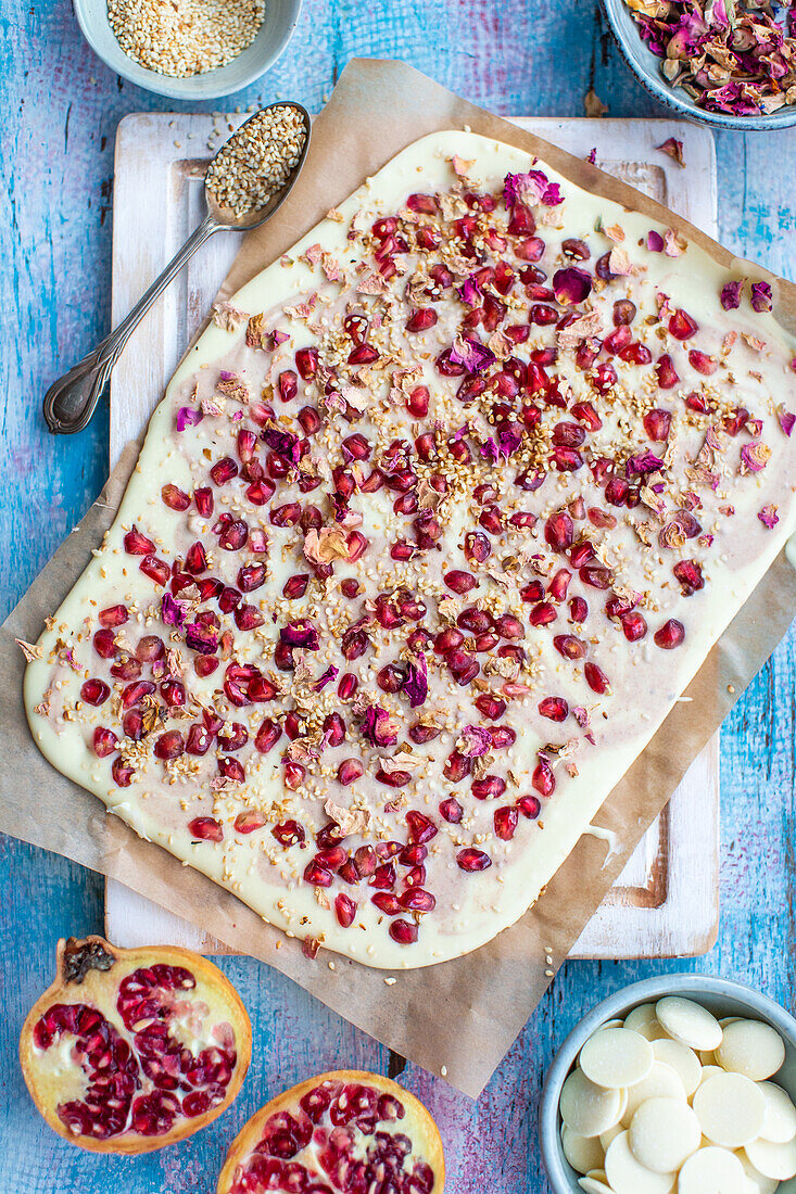 Weiße Bruchschokolade mit Granatapfelkernen und Rosenblättern