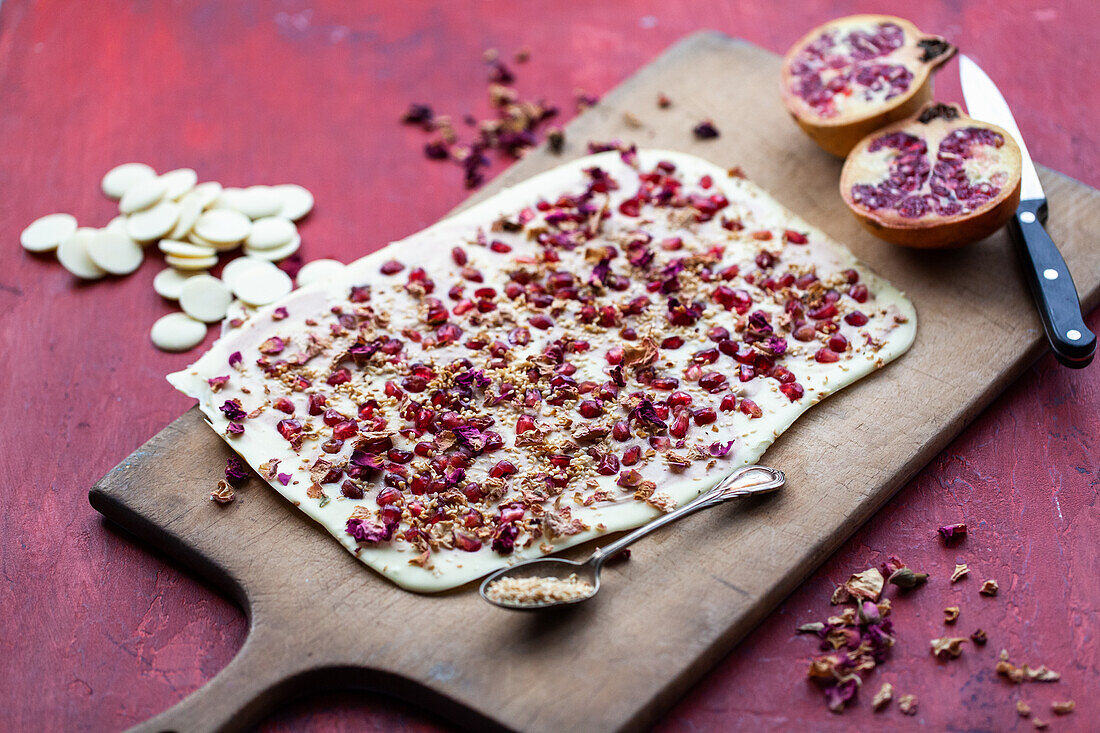 Weiße Bruchschokolade mit Granatapfelkernen und Rosenblättern