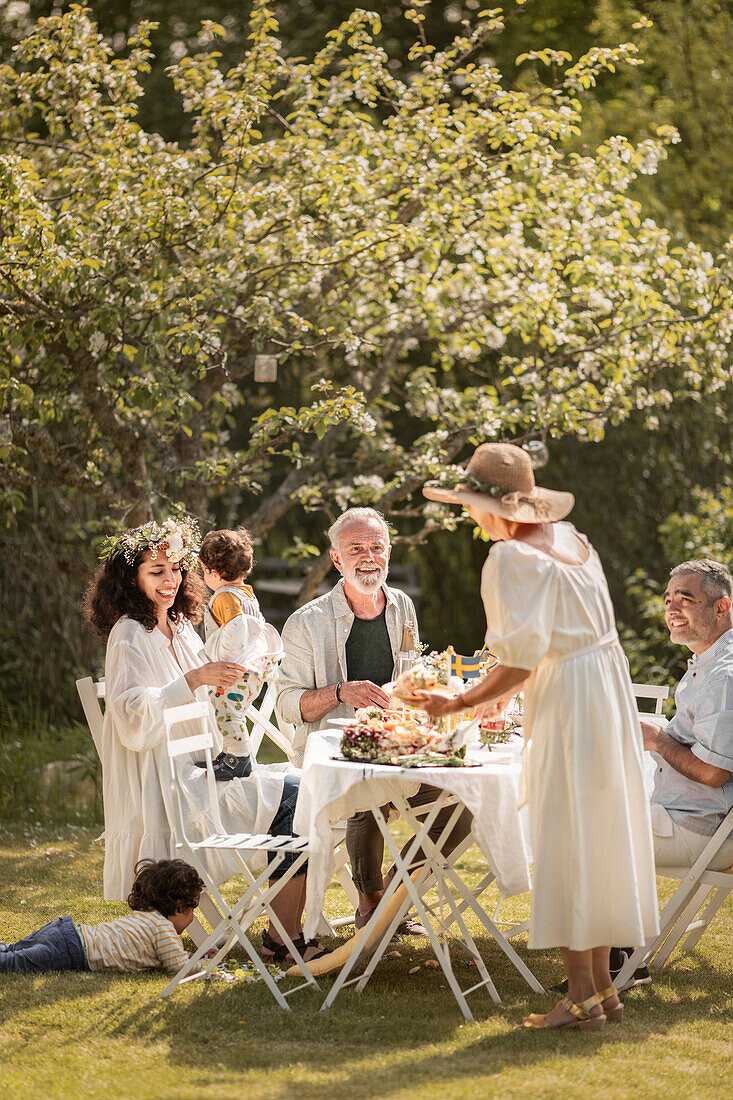 Family celebrating midsummer with a garden party (Sweden)