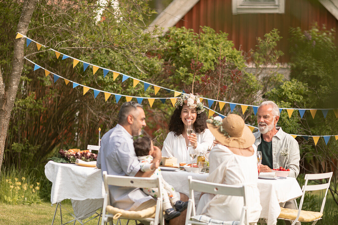 Family celebrating midsummer in the garden (Sweden)