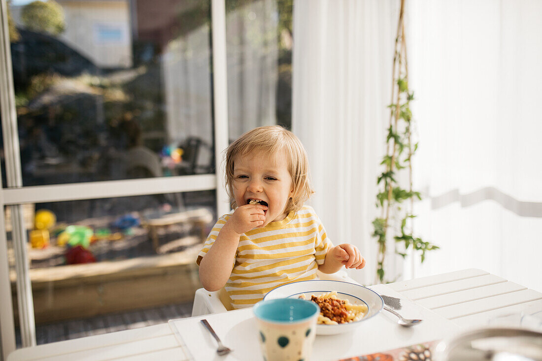 Kleines Mädchen isst Nudeln mit Hackfleischsauce