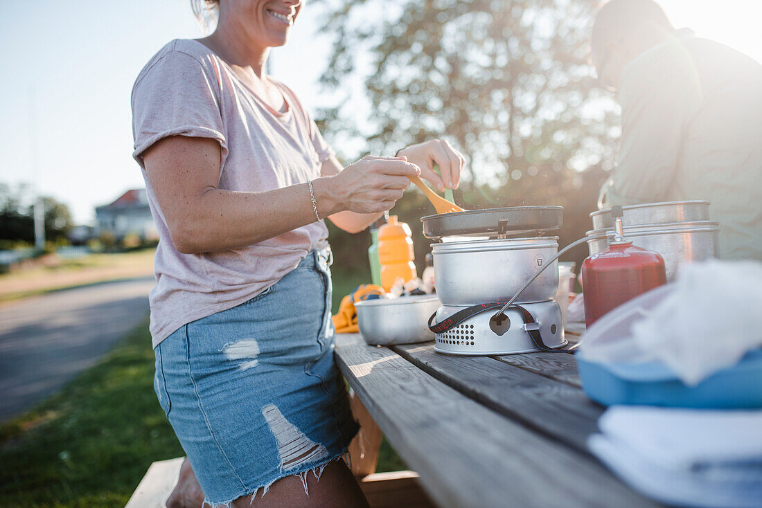 Frau bereitet das Essen im Freien zu
