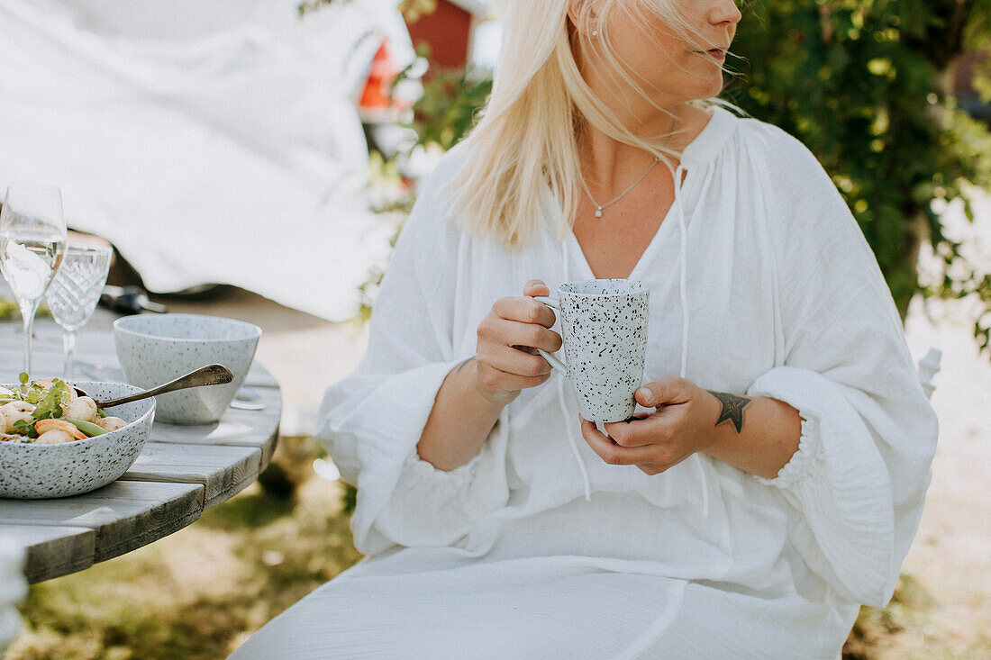 Woman in garden holding mug